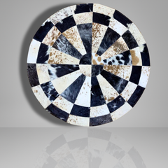 Round decorative plate with black, white, and brown pattern on a gray background
