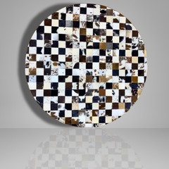 Round table top with a checkered pattern of cowhide leather on a gray background