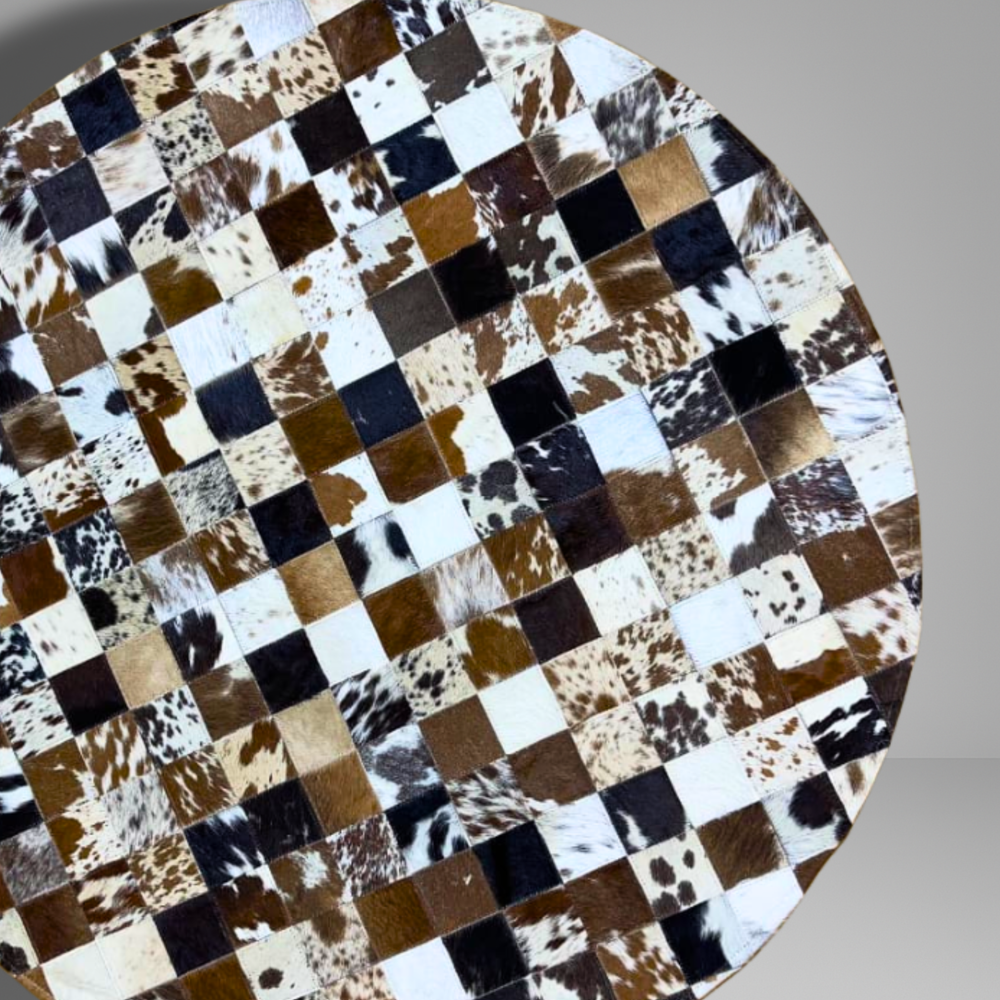 Round table with a checkered pattern made of cowhide leather on a gray background