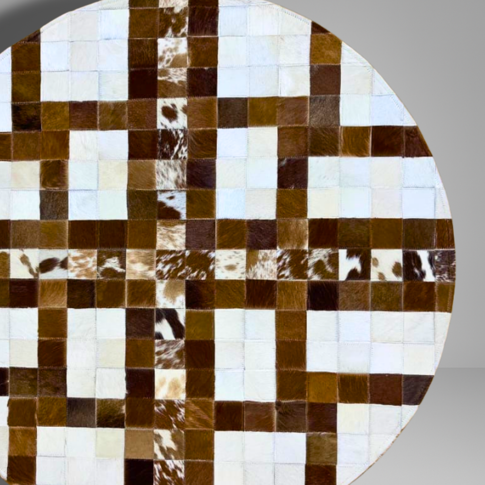 Round cowhide rug with a patchwork pattern of brown, white, and beige squares.